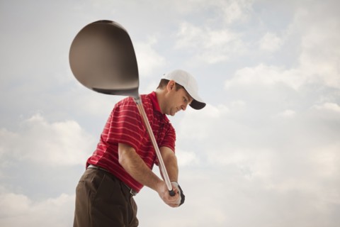 Caucasian golfer swinging golf club