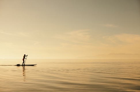 Caucasian woman standing on paddle board