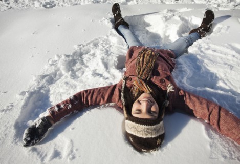 Caucasian woman making snow angel