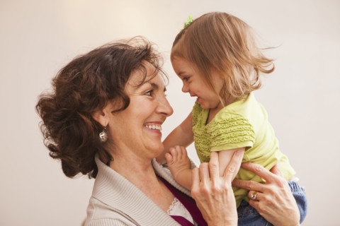 Caucasian grandmother holding granddaughter