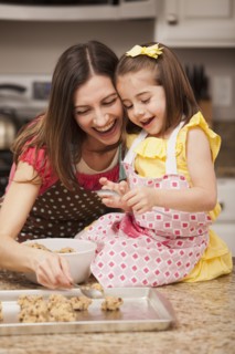 Caucasian mother and daughter baking cookies