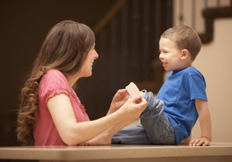 Caucasian mother putting bandage on son's knee