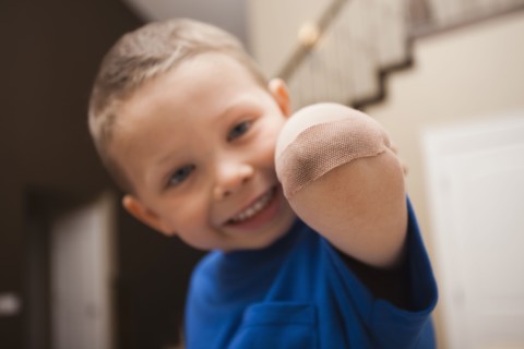 Caucasian boy with bandage on elbow