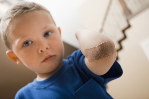 Caucasian boy with bandage on elbow