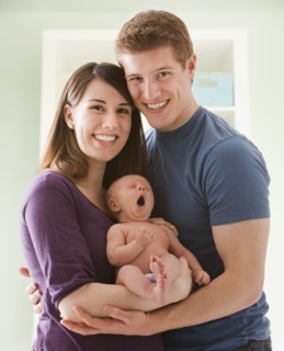 Caucasian mother and father holding baby girl