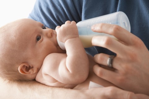 Caucasian father feeding baby girl
