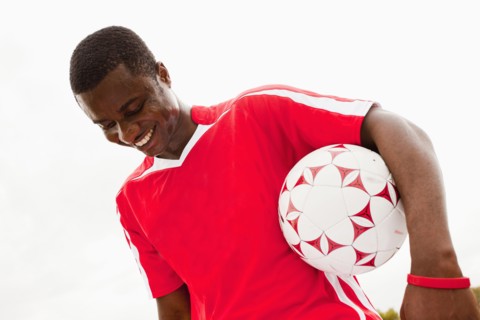 Black soccer player holding ball