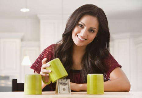 Mixed race woman finding money underneath cup