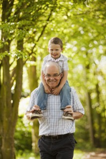 Caucasian grandfather carrying grandson on shoulders