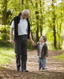 Caucasian grandfather and grandson walking in woods