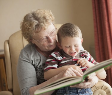 Caucasian grandmother reading book to grandson