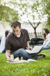 Caucasian man studying in grass