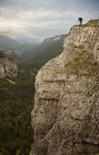 Caucasian man taking photographs from edge of cliff