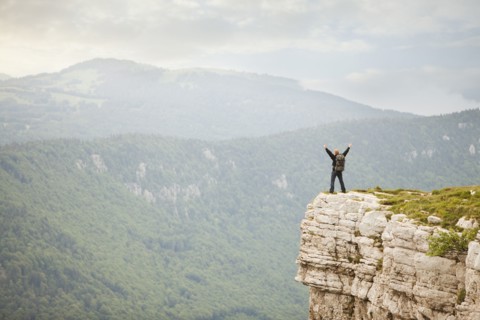 Caucasian man standing on remote cliff