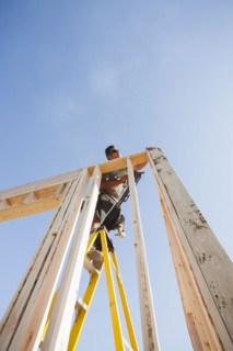 Caucasian man using nail gun on frame