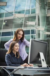 Caucasian businesswomen working at computer
