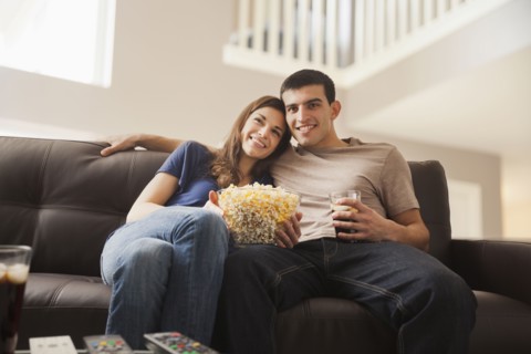Couple watching television on sofa