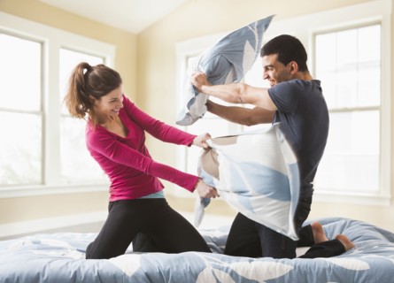 Couple having pillow fight on bed