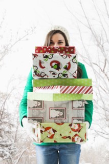 Caucasian woman holding Christmas gifts in snow
