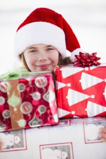 Caucasian boy in Santa hat holding Christmas presents