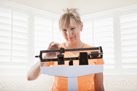 Caucasian woman weighing herself