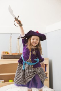 Caucasian girl playing dress up