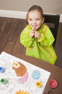 Caucasian girl painting at table