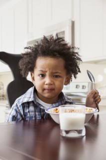 Mixed race boy eating at table