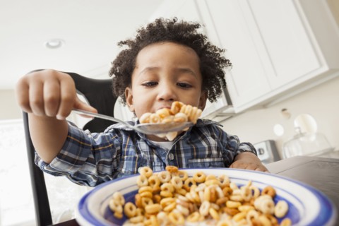 Mixed race boy eating at table