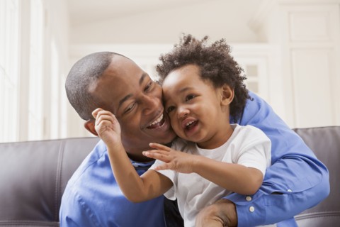 Father and son relaxing on sofa