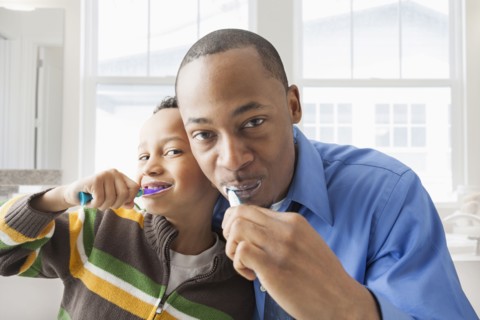 Father and son brushing their teeth