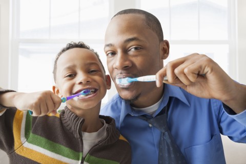 Father and son brushing their teeth