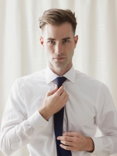 Caucasian businessman adjusting his tie