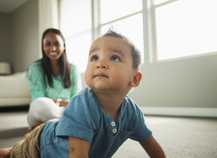 Baby boy crawling in living room