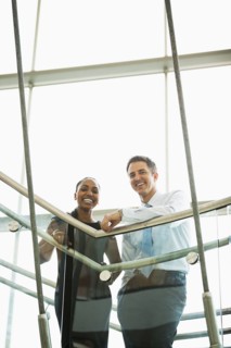 Business people smiling on office staircase