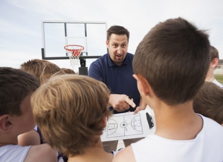 Caucasian coach talking to basketball team