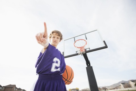 Caucasian basketball player holding out finger on court