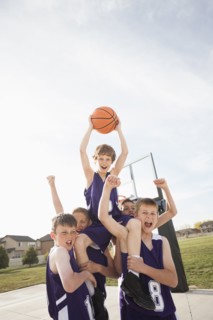 Caucasian basketball team cheering on court