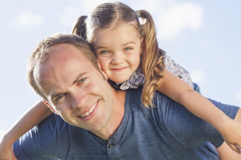 Caucasian father carrying daughter on shoulders