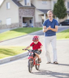 Caucasian father teaching son to ride bicycle