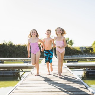 Caucasian children running on dock