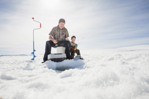 Caucasian father and son ice fishing