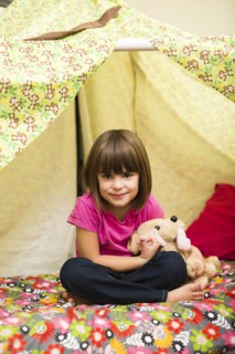 Caucasian girl sitting in blanket fort