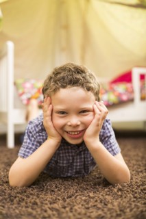 Caucasian boy smiling in bedroom