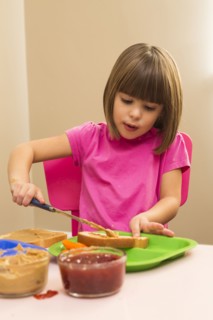 Caucasian girl making sandwich in kitchen