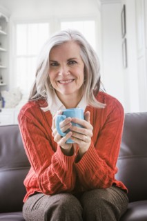 Portrait of Caucasian woman drinking coffee on sofa