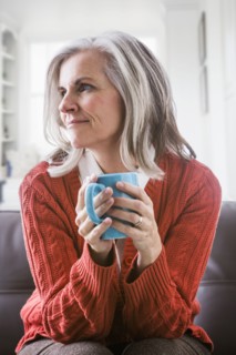 Pensive Caucasian woman drinking coffee