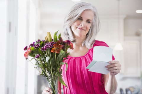Caucasian woman receiving bouquet of flowers