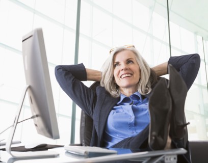 Confident Caucasian businesswoman with feet up on desk