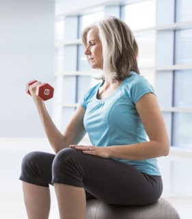 Caucasian woman doing biceps curls with dumbbell